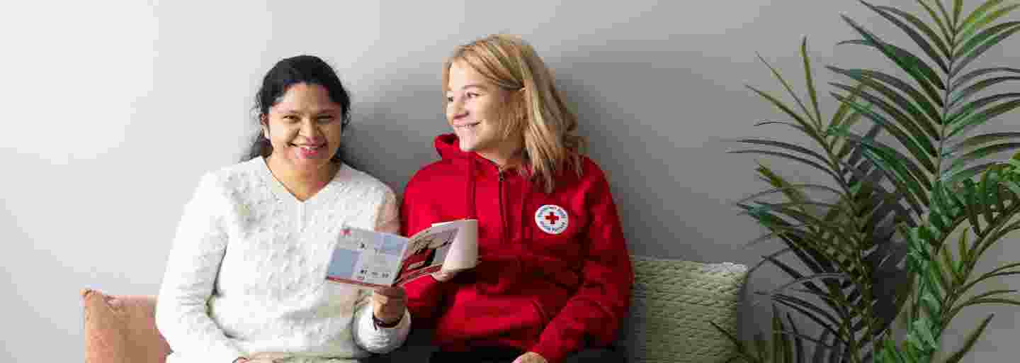 Kaksi naista juttelemassa Punaisesta Rististä.