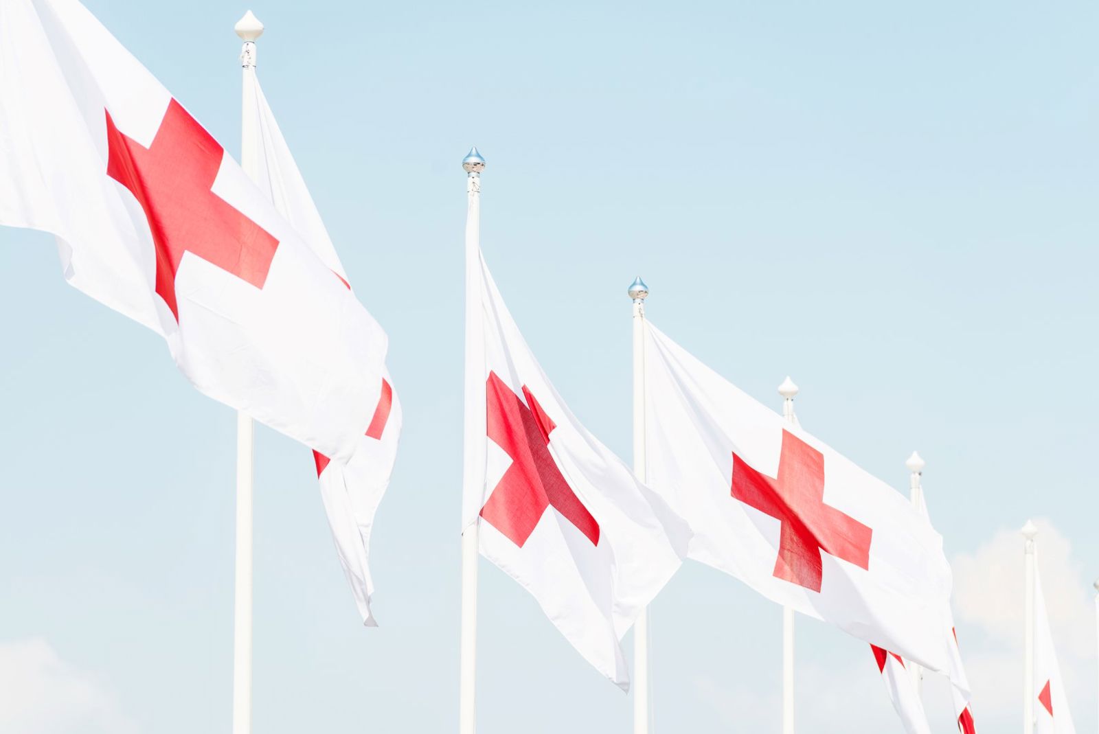 Punaisen Ristin lippuja liehumassa lipputangossa.