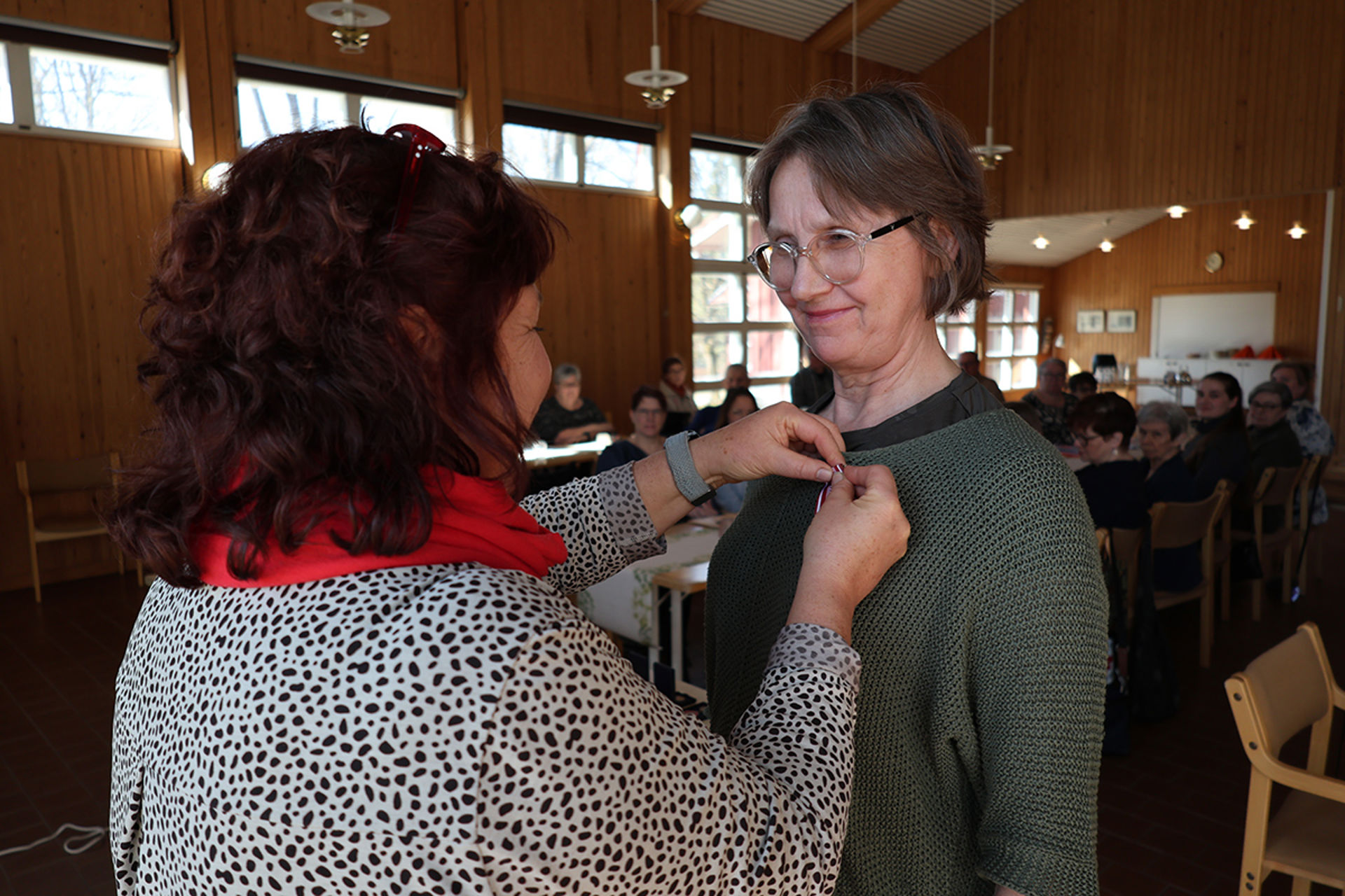 Marja-Leena Kapilo saa hopeisen ansiomitalin toiminnanjohtaja Annalena Sjöblomilta.