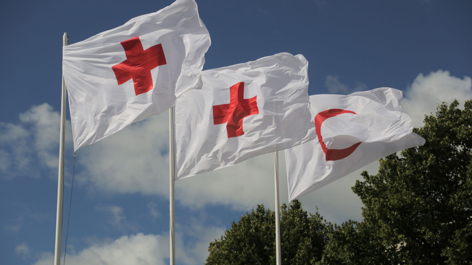 Punaisen Ristin ja puolikuun lippuja lipputangossa