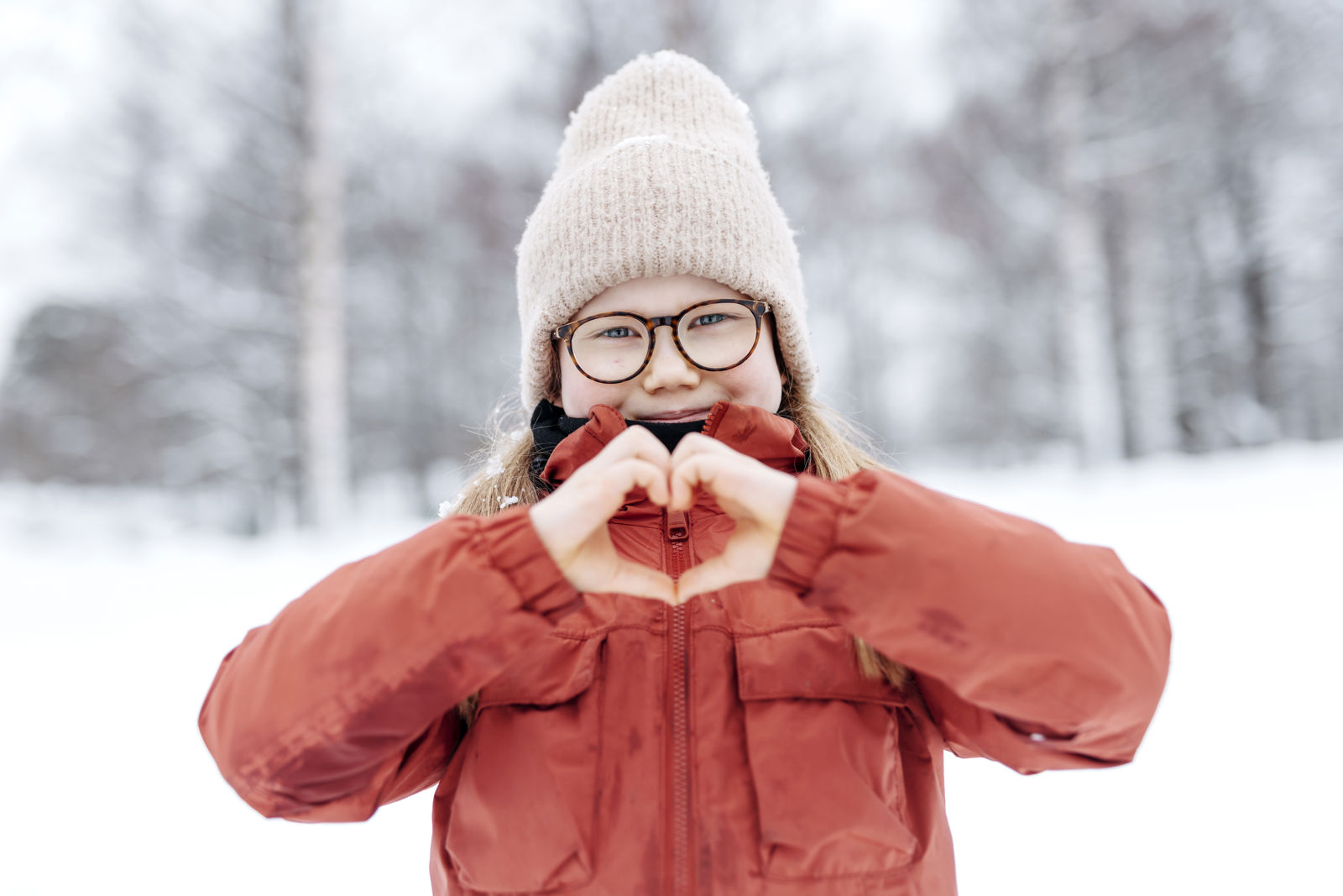 Barnet formar ett hjärta med sina händer.
