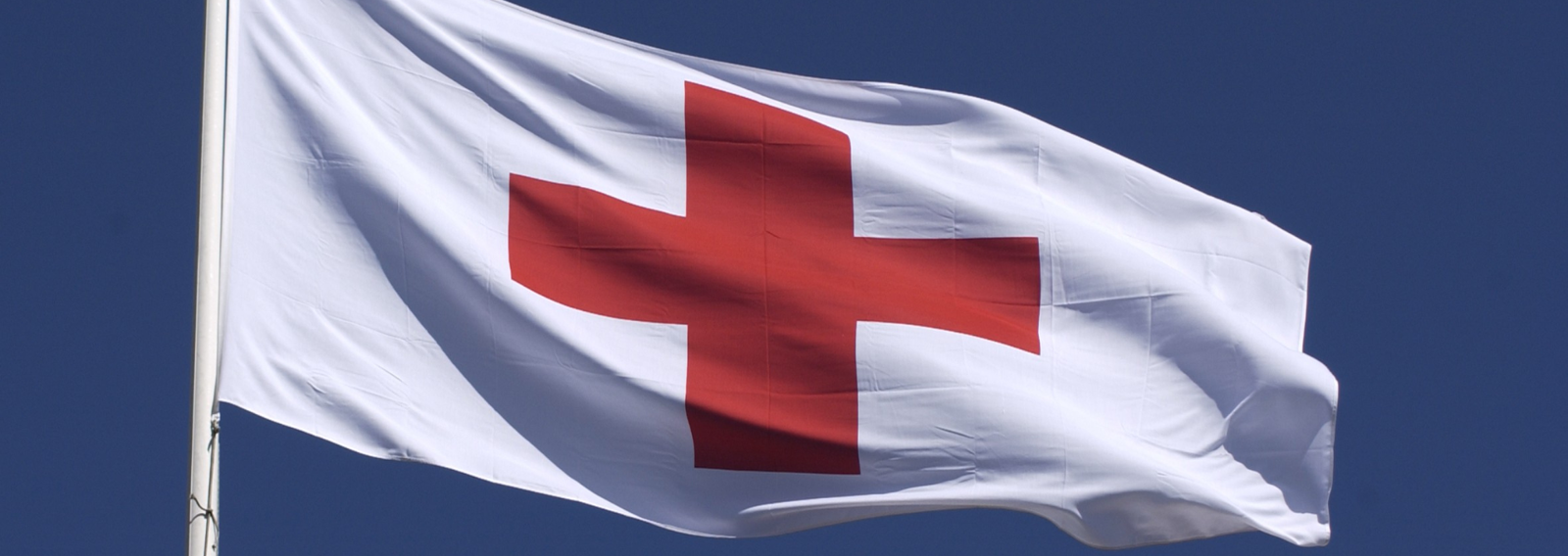 Punaisen Ristin lippu liehumassa lipputangossa