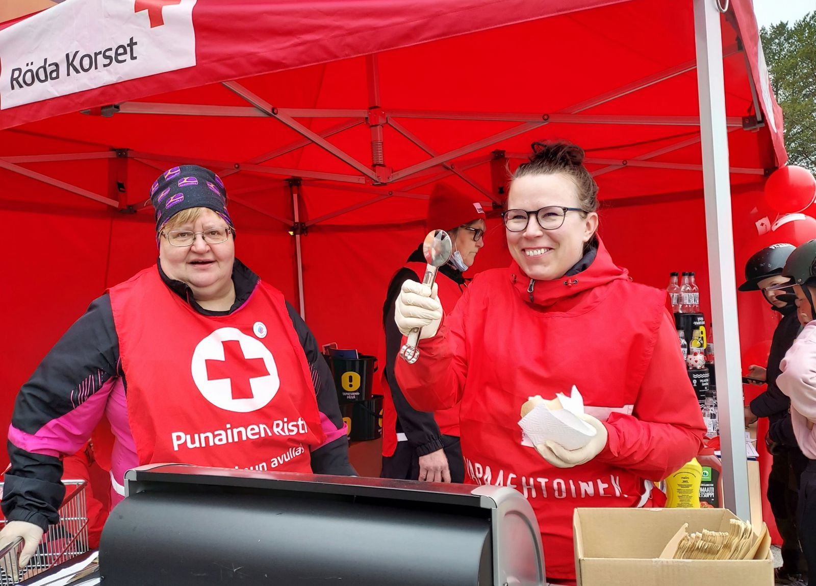 Ihminen jakaa ruokaa jonottaville ihmisille. 