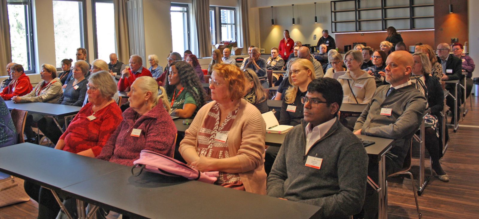 Kuvassa yleisö kuuntelee diaesitystä toimintalinjauksesta Oulun piiriseminaarissa. 