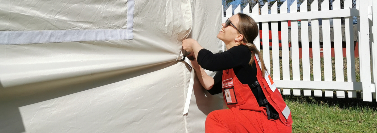 Punaisen Ristin vapaaehtoinen pystyttämässä EVAK-telttaa.